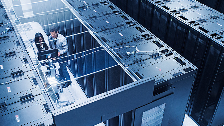 A man and a woman working in computer server stacks