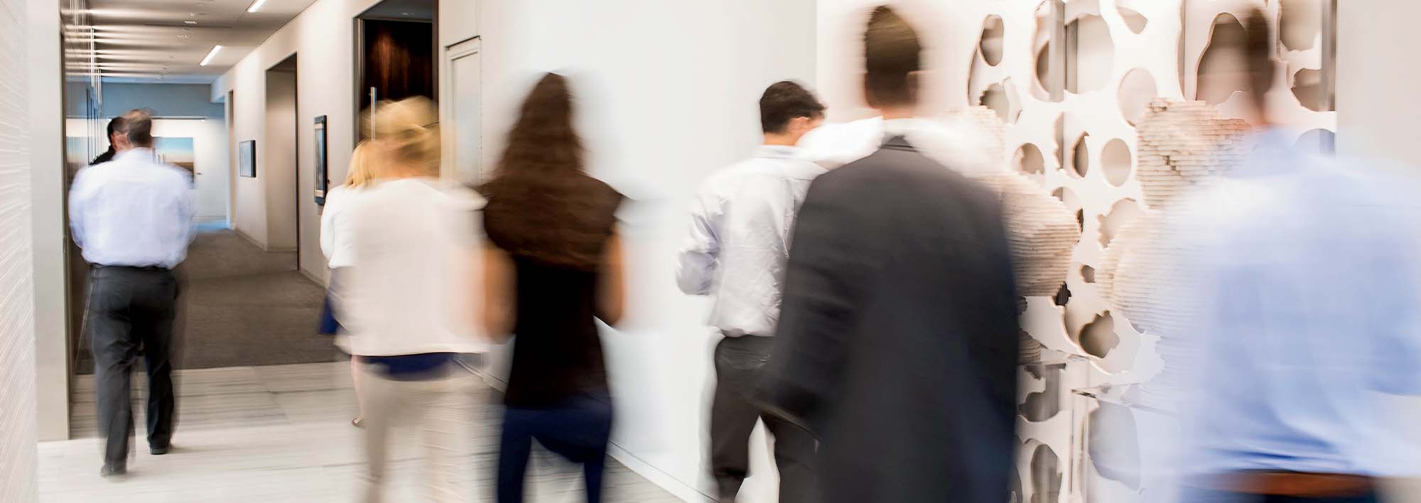Business people talking in a hallway with lots of windows