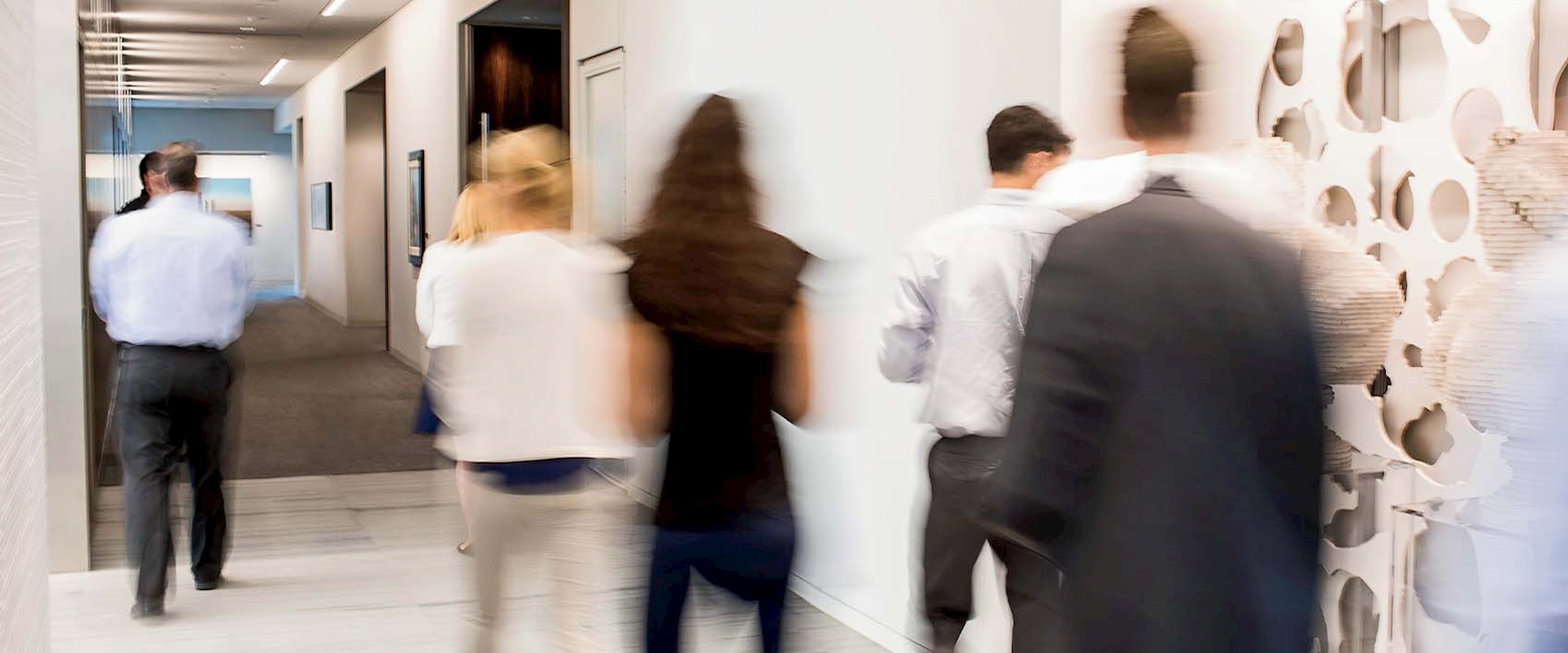 Business people talking in a hallway with lots of windows