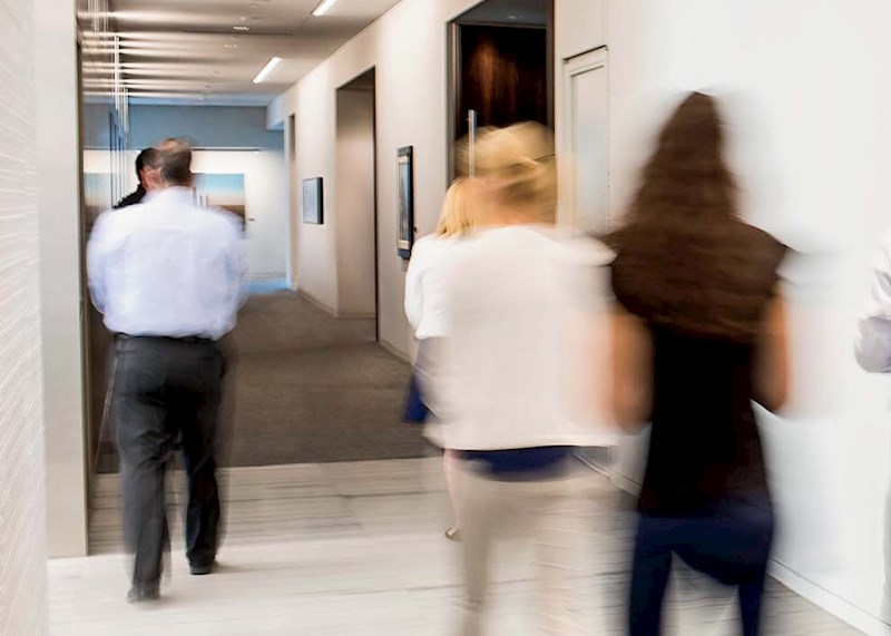 Business people talking in a hallway with lots of windows
