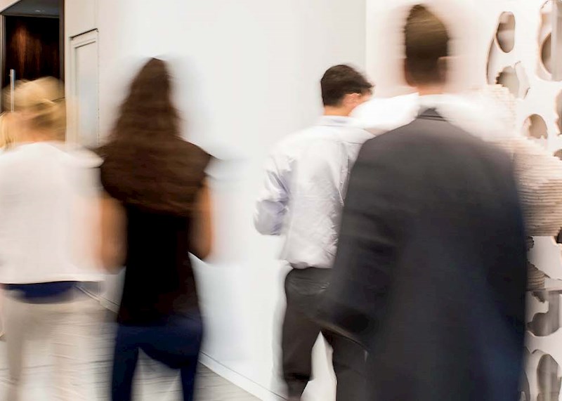 Business people talking in a hallway with lots of windows