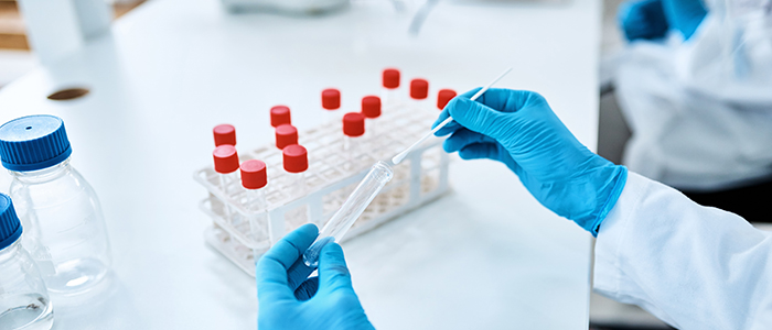 In a lab, hands working with test tubes