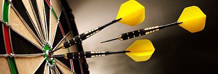 Darts hitting the bullseye on a dartboard