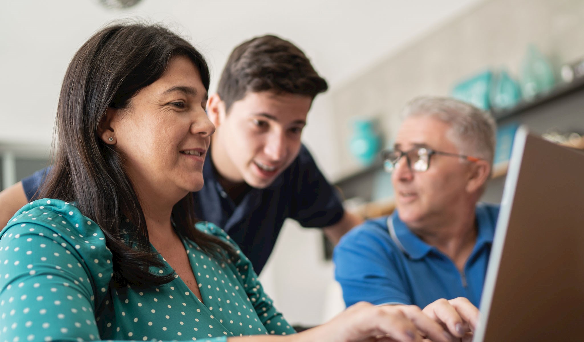 Parents and their son looking at a laptop