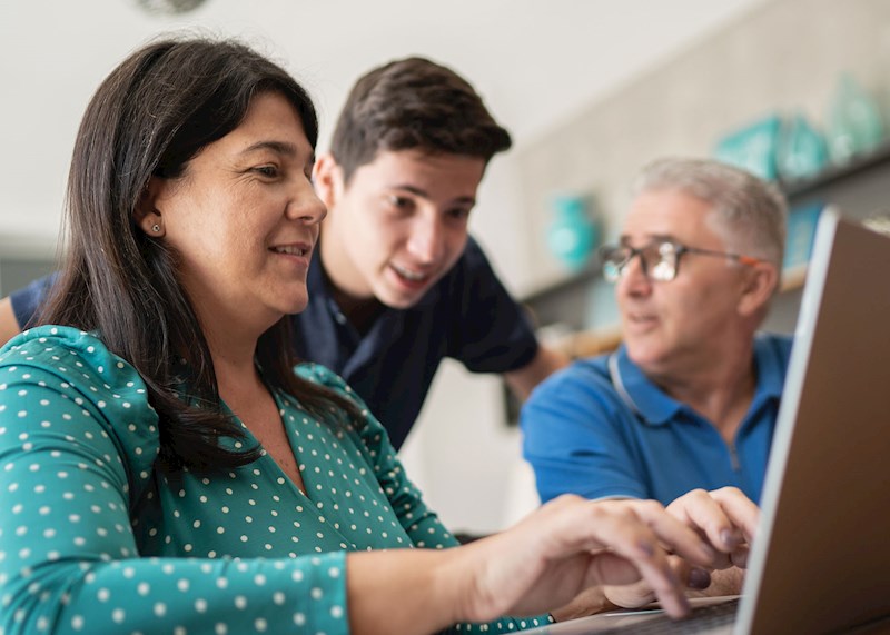 Parents and their son looking at a laptop