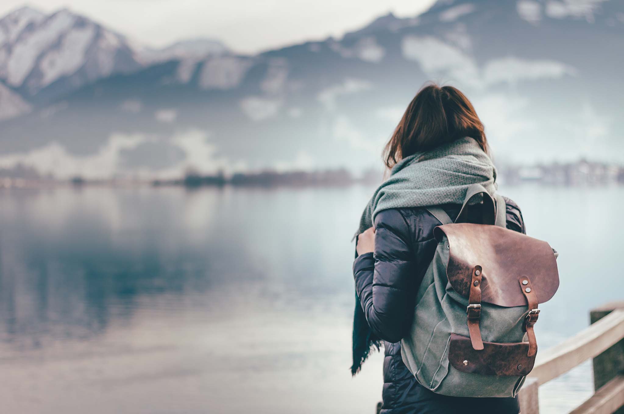 Girl with a backpack on looking at a lake