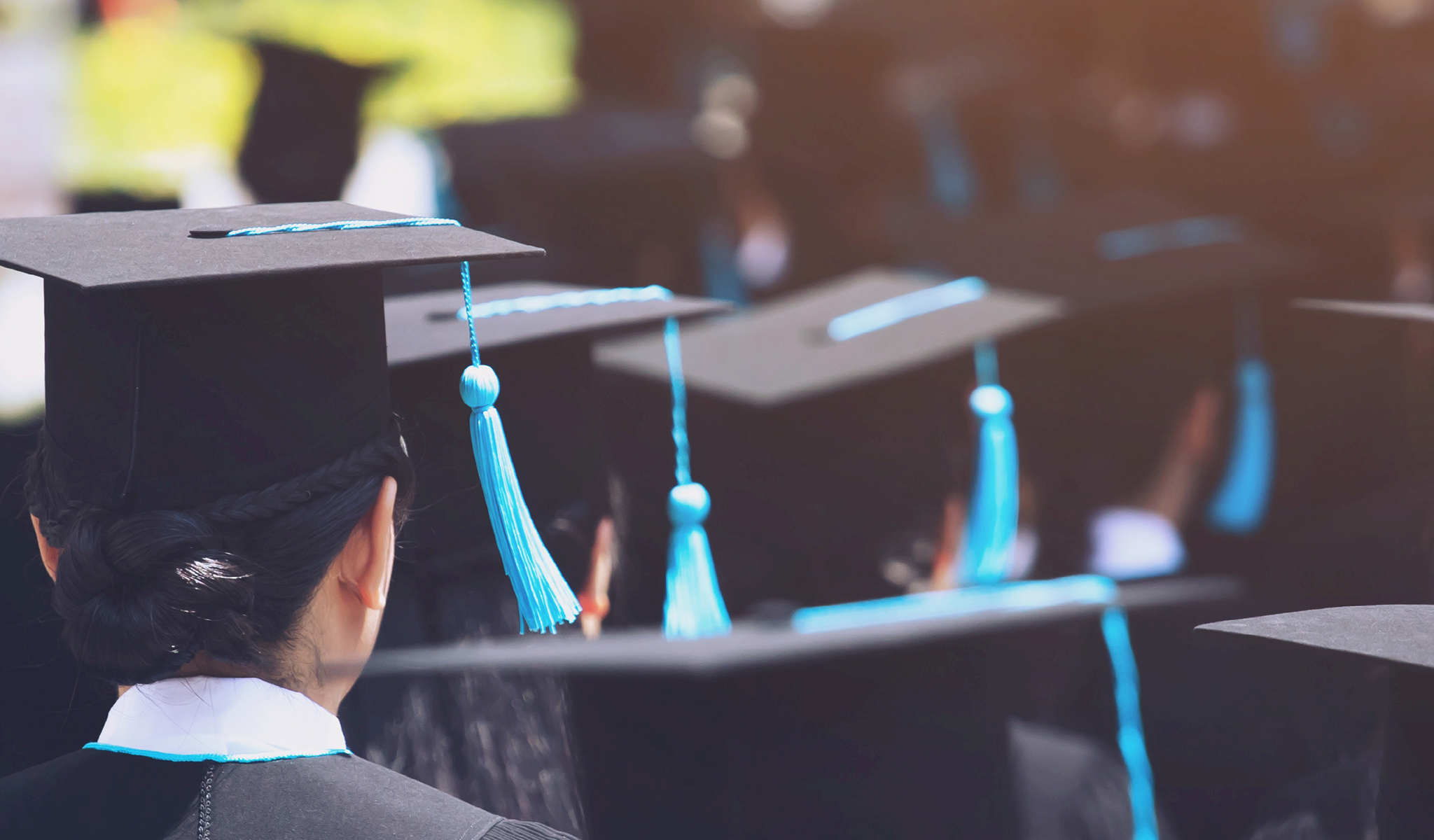 Back of students' heads wearing caps and gowns