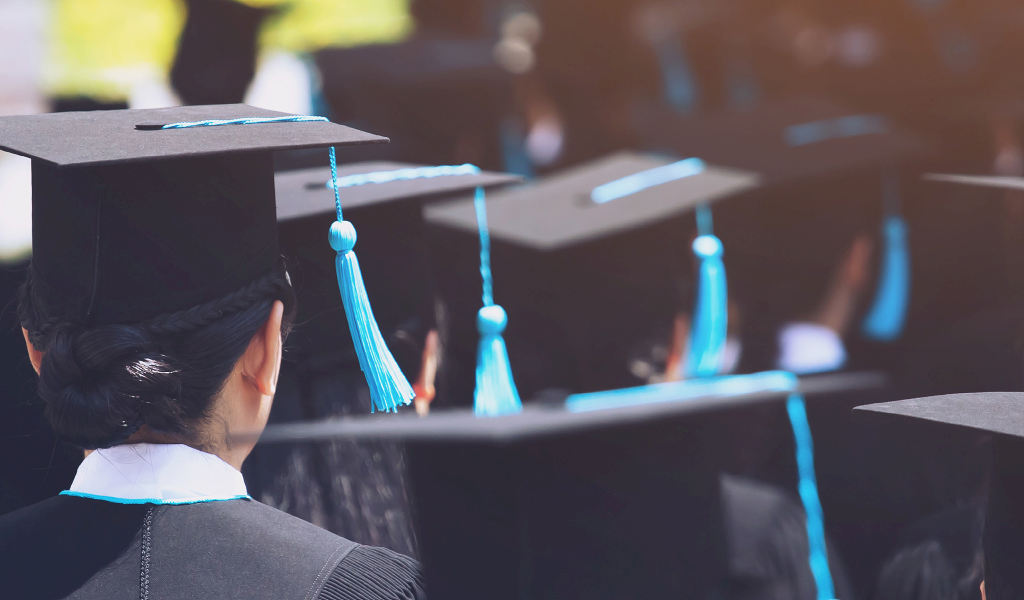 Back of students' heads wearing caps and gowns