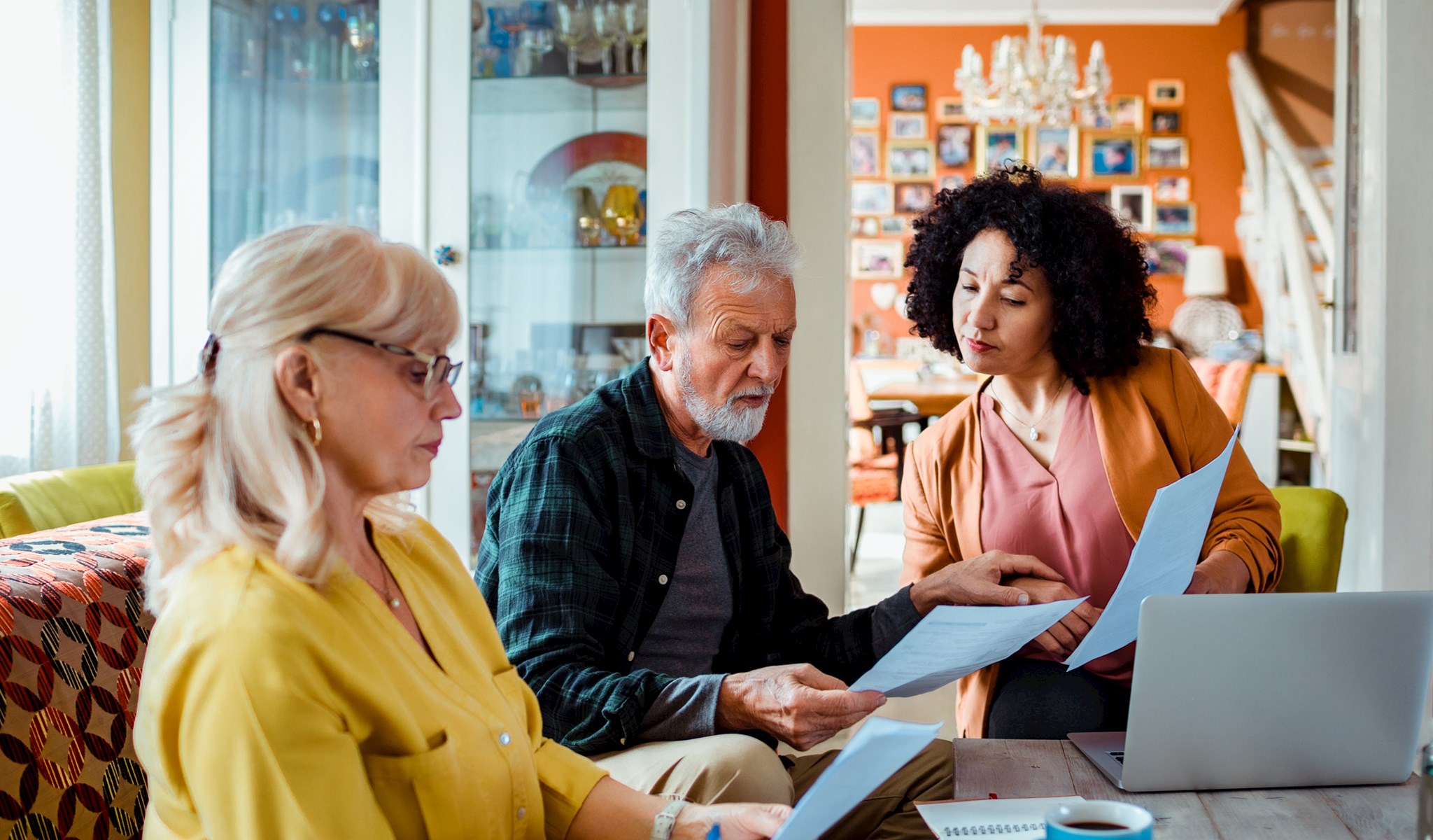 Three people sitting around a table looking at papers